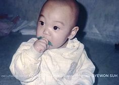 a baby sitting on the floor chewing on something