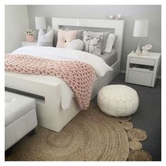 a white bed sitting in a bedroom on top of a rug