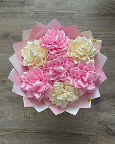 pink and white paper flowers sitting on top of each other