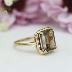 a close up of a ring with flowers in the background