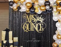 a black and gold balloon arch with congratulationss on it in front of a backdrop