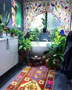 a bathroom with plants and rugs on the floor