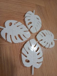 four white plastic leaves sitting on top of a wooden table