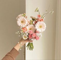 a person holding a bouquet of flowers in their hand