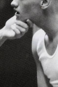 a black and white photo of a man brushing his teeth