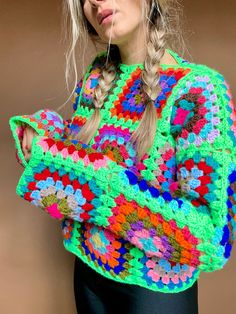 a woman wearing a multicolored crochet sweater