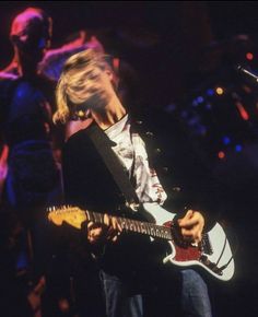 a man playing an electric guitar on stage