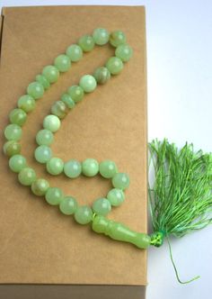 Green onyx mini mala with tassel A portable gemstone mini-mala that will easily fit into a pocket, purse or yoga bag. Compact and light weight, this pocket mala contains 33 x 10mm beads. Perfect for keeping with you all day long or at your bedside - for a few moments of quiet retreat and meditation. The ideal anti-stress gift. Traditionally evolved from prayer beads, worry beads no longer need to have religious significance but are a simple tool for calming and focusing the mind. Contact me if y Agate Mala With 108 Beads Gift, Agate Mala With 108 Beads As Gift, Green Gemstone Beads Mala As Gift, Green 8mm Beads Mala Gift, Hand-strung Green Mala Gift, Green Hand-strung Mala As Gift, Hand-strung Green Mala As Gift, Gemstone Beads Mala As Gift, Round Gemstone Beads Mala As Gift