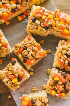 several pieces of candy cornbread bars on a piece of parchment paper with some candy in the middle