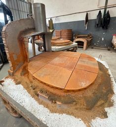 a large piece of wood sitting on top of a cement slab in a building next to other pieces of furniture