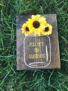 a wooden sign with sunflowers in a mason jar that says you are my sunshine