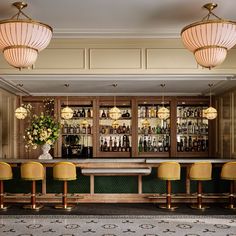 a bar with yellow chairs and gold lamps