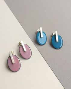 three pairs of earrings sitting next to each other on top of a white and gray surface