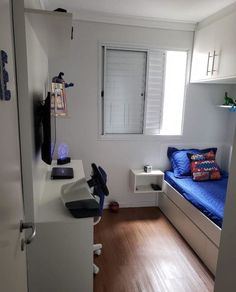 a room with a bed, desk and chair next to a window on the wall