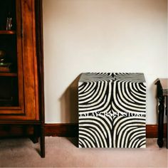 a black and white box sitting on the floor in front of a book shelf with books