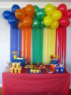 a table topped with lots of colorful balloons