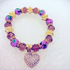 Bracelet Crystal Heart In Purple And Golden.Hand Painted Beads. Very Brilliant! Brand New In Packaging! Very Pretty! Purple Round Bead Jewelry For Valentine's Day, Purple Round Beads Jewelry For Valentine's Day, Purple Heart Charm Bracelet For Valentine's Day, Purple Adjustable Heart Bracelet For Valentine's Day, Adjustable Purple Heart Bracelet For Valentine's Day, Valentine's Day Purple Bracelet With Heart Charm, Adjustable Purple Jewelry With Heart Charm, Purple Heart Jewelry With Colorful Beads, Purple Heart Bracelet For Valentine's Day