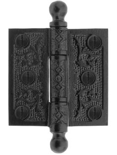 an iron door hinge with decorative designs on the front and back sides, in black