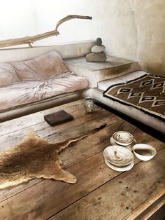 a living room filled with furniture and a rug on top of a wooden table in front of a couch