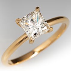 a yellow gold ring with a princess cut diamond