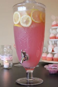 a glass filled with pink liquid and lemon slices