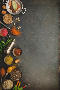 an overhead view of spices and seasonings on a dark background with space for text