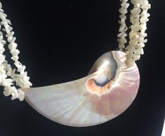 "Bold Statement Beach necklace that has a huge shell suspended from four strands of white shell beads. Beige, tan, white and pink colors. The shell is about 3.375\" wide; the necklace is about 20\" around.  Also, please take a look at my storefront at: https://www.etsy.com/shop/FabFinds42?ref=seller-platform-mcnav I have a wide selection of one-of-a-kind items, from clothing and toys to home decor and gift items, and I add new things almost every day." Unique Mother Of Pearl Shell Necklace, White Shell-shaped Pearl Necklace, White Abalone Shell-shaped Necklace, Pearl White Shell Necklace, White Unique Shell Necklace, White Abalone Shell Necklace, Handmade White Abalone Shell, White Shell-shaped Mother Of Pearl Necklace, Hawaii Necklace