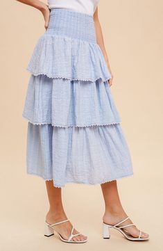 Introducing our Smocked Ruffle Tiered Skirt - the perfect blend of chic and comfort with its elastic waist and delicate lace tiers. This skirt will have you looking stylish without sacrificing your freedom of movement. (Looking fabulous and feeling free? Now that's a win-win situation!) Tiered Layered Hem Bottoms, Tiered Bottoms With Layered Hem And Flowy Fit, Feminine Tiered Ruffled Skirt, Tiered Bottoms With Layered Hem, Tiered Layered Hem Feminine Bottoms, Feminine Skirted Bottoms With Layered Hem, Spring Tiered Voluminous Skirt, Feminine Tiered Bottoms With Layered Hem, Breezy Tiered Skirt