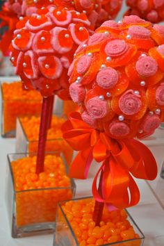 orange and pink candies are arranged in vases