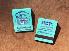 two blue business cards sitting on top of a brown carpet