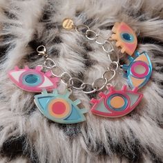 *This colorful and unique bracelet matches our earring and necklace set and is super cool! It includes 5 eye charms and a thick silver tone chain.  The bracelet is made at the average 7.5" length, but can be made longer or shorter at no extra cost! DETAILS: *This bracelet features multi-color eyeball charms on a silver chain.   *Each charm is 1 inch tall and 1.5 inches wide.  *The eyeball charms are a mix of frosted green, sherbet, neon pink, and mirror blue acrylic. *The pendants were designed digitally by BC, then laser cut from 1/8th of an inch thick acrylic. *They were secured together, and the back of design has a thin layer of white acrylic as a backing for extra durability. *Each charm was attached to the thick silver tone chain by matching jump rings, added to a thinner chain.  *Th Fun Silver Metal Jewelry, Handmade Fun Metal Jewelry, Fun Handmade Metal Jewelry, Trendy Multicolor Nickel Free Charm Bracelet, Fun Nickel-free Metal Jewelry, Novelty Pink Jewelry For Festival, Trendy Multicolor Evil Eye Jewelry, Novelty Multicolor Metal Jewelry, Acrylic Charm Necklace