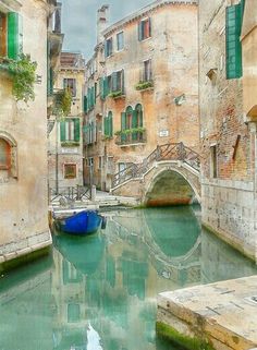 a small boat is in the water between two buildings