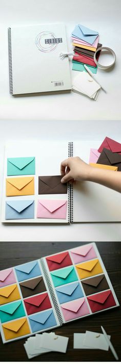 an open notebook with several different colored envelopes on the cover and in front of it