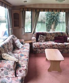 a living room with couches and windows looking out onto the water in front of them