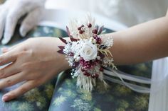 a bride's bouquet sits on top of an open book as she holds it in her hand