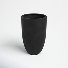 a black vase sitting on top of a white table