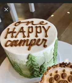 a cake with the words happy camper written on it next to a piece of pie