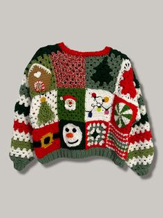 a green and red sweater with snowmen, santa clauss and other holiday decorations