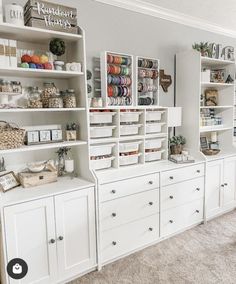 a room filled with lots of white cabinets and shelves full of crafting supplies on top of them