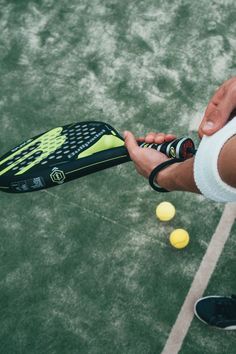 a tennis player is about to hit the ball with his racket and balls are on the court