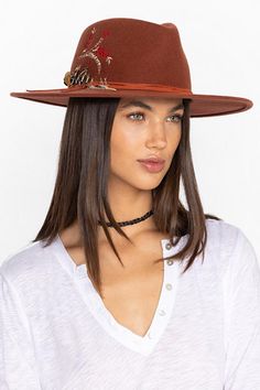 Crafted from 100% wool, the Hummingbird Heather Hat is available in an earthy rust color. Featuring a mid-height crown and a wide brim, this hat is finished with intricate placement embroidery and a decorative feather placed thoughtfully at the hatband. Style with a denim-on-denim look and western style boots for an eclectic ensemble. Johnny Was Women's Hummingbird Feather Hat in Rust Brown, Denim Western Style Wide Brim Felt Hat For Fall, Western Wool Hat Bands, Wide Brim Felt Hat For Rodeo In Fall, Brown Felt Hat With Flat Crown For Fall, Fall Rodeo Felt Hat With Short Brim, Country Style Fall Rodeo Hat, Western Style Curved Brim Fedora For Fall, Fall Fedora With Short Brim For Rodeo, Curved Brim Hats For Rodeo In Fall