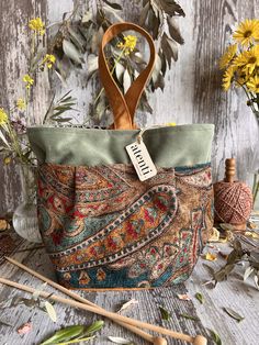 an image of a purse with flowers and knitting needles