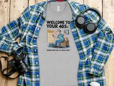 a t - shirt with the words welcome to your 40s on it next to some binoculars