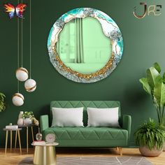 a living room with green walls and a round mirror hanging on the wall above it