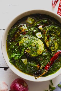 a white bowl filled with green vegetable soup