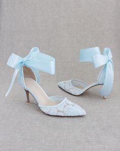 a pair of white shoes with blue bows on the toes and heels are sitting next to each other