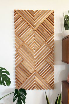 a wooden wall hanging next to a potted plant