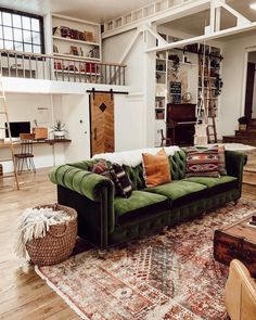 a living room filled with furniture and a large rug on top of a hard wood floor