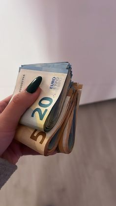 a woman's hand holding stacks of money