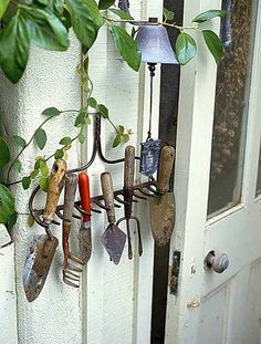 garden tools hanging from the side of a door